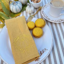 Handgefertigte Serviette Herbst mit Kürbis aus currygelbem Leinen von Atelier Luhabru, gold bestickt, mit Kaffeetasse und Macarons